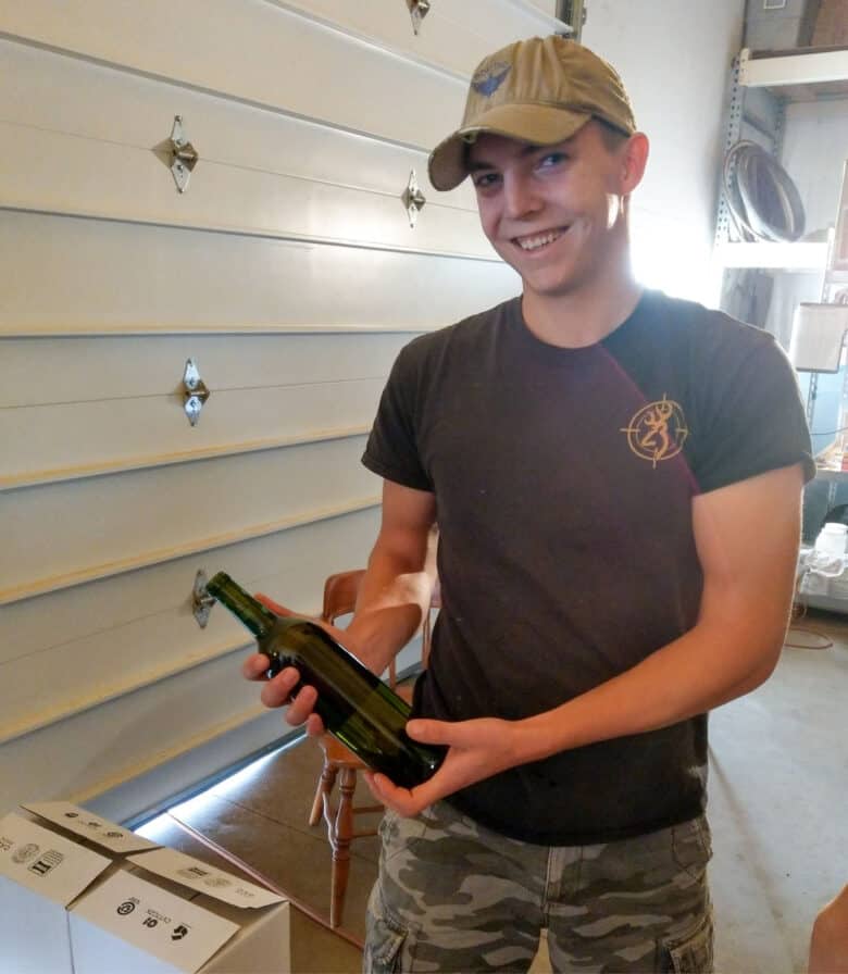 Bottling 2017 Vintage - a worker holding a bottle of wine.